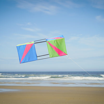 The Strike Double Box Kite soaring in the sky, showcasing its vibrant design and multiple sail surfaces for enhanced stability.