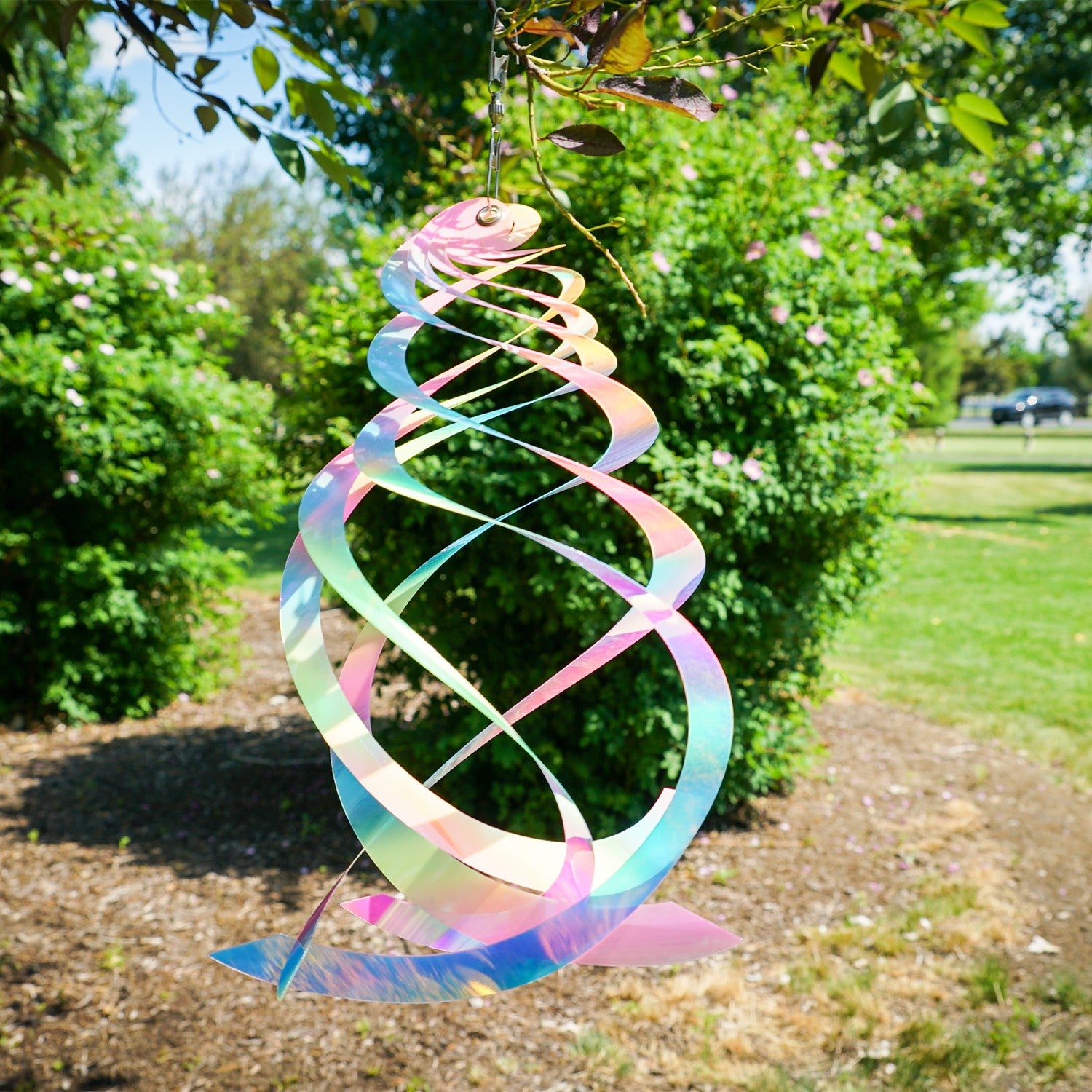 Vibrant Striped Iridescent Crystal Spinner made of Mylar, hanging outdoors with colorful reflections in sunlight, perfect for garden decor.