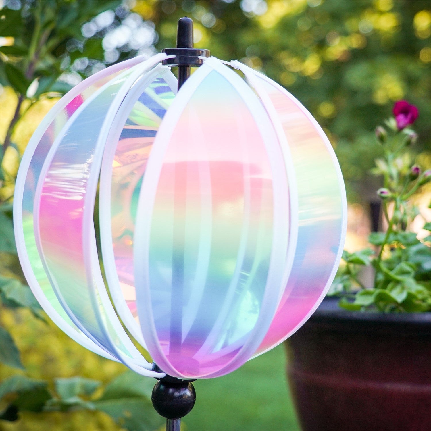 Vibrant 8.5-inch Striped Iridescent Gazing Ball Spinner with colorful patterned panels, set against a lush garden background.