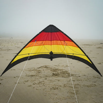 The Sunset 55" Sport Kite showcasing a bold, colorful design in flight against a clear blue sky is perfect for outdoor activities and easily recognizable.