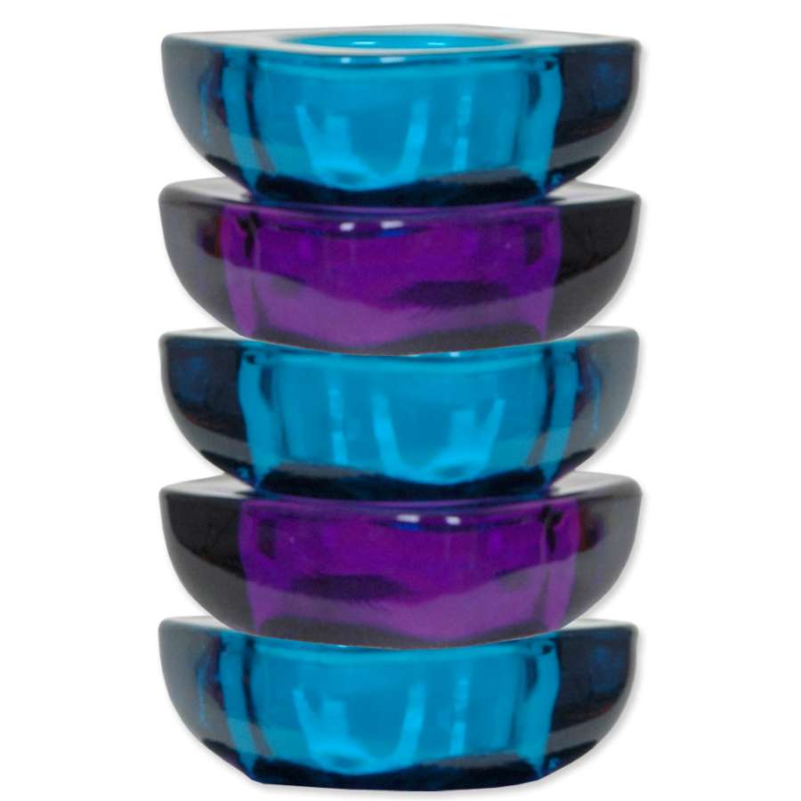 Set of five purple and blue tealight candle holders arranged in a garden setting, creating a cozy ambient light.