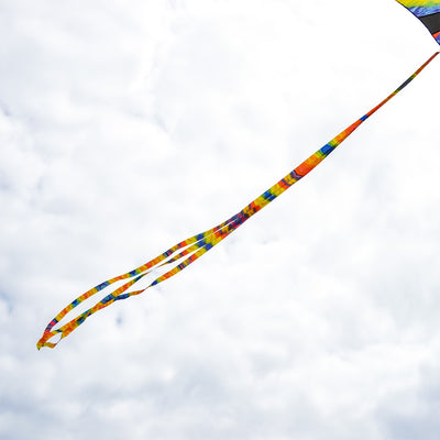 Set of three colorful 15' Tie Dye tails displayed in the wind, attached to a kite during an outdoor kite flying event.