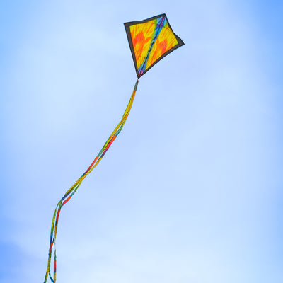 Tie Dye 30 inch Diamond Kite flying high in the sky with vibrant colors and 12-foot streamer tails swaying in the wind.