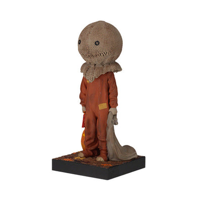 Trick 'r Treat Sam Glow in the Dark Bobblehead displayed on a shelf, showcasing its intricate detail and glowing effect in a dimly lit room.