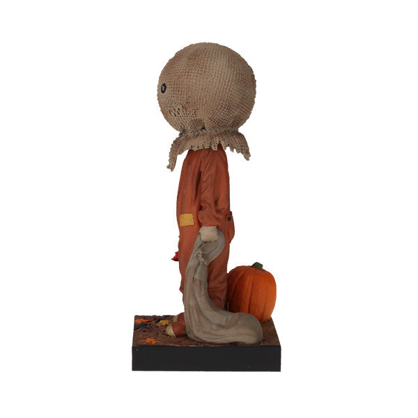 Trick 'r Treat Sam Glow in the Dark Bobblehead displayed on a shelf, showcasing its intricate detail and glowing effect in a dimly lit room.