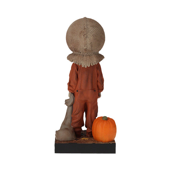 Trick 'r Treat Sam Glow in the Dark Bobblehead displayed on a shelf, showcasing its intricate detail and glowing effect in a dimly lit room.