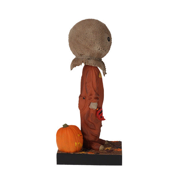 Trick 'r Treat Sam Glow in the Dark Bobblehead displayed on a shelf, showcasing its intricate detail and glowing effect in a dimly lit room.