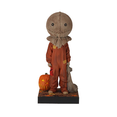 Trick 'r Treat Sam Glow in the Dark Bobblehead displayed on a shelf, showcasing its intricate detail and glowing effect in a dimly lit room.