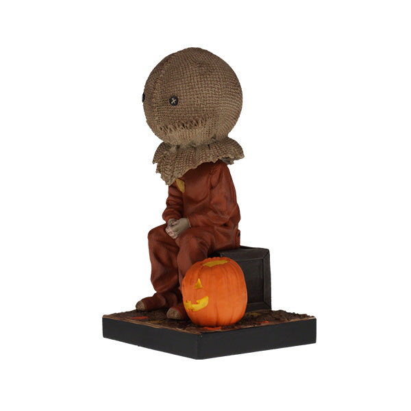 Trick 'r Treat Sam Sitting Bobblehead, a 6-inch collectible figure presenting Sam with pumpkin-like head, perfect for Halloween decor and horror enthusiasts.