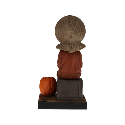 Trick 'r Treat Sam Sitting Bobblehead, a 6-inch collectible figure presenting Sam with pumpkin-like head, perfect for Halloween decor and horror enthusiasts.