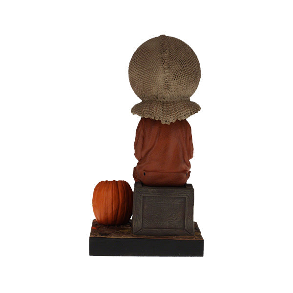 Trick 'r Treat Sam Sitting Bobblehead, a 6-inch collectible figure presenting Sam with pumpkin-like head, perfect for Halloween decor and horror enthusiasts.
