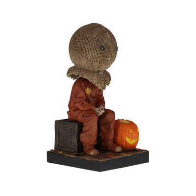 Trick 'r Treat Sam Sitting Bobblehead, a 6-inch collectible figure presenting Sam with pumpkin-like head, perfect for Halloween decor and horror enthusiasts.