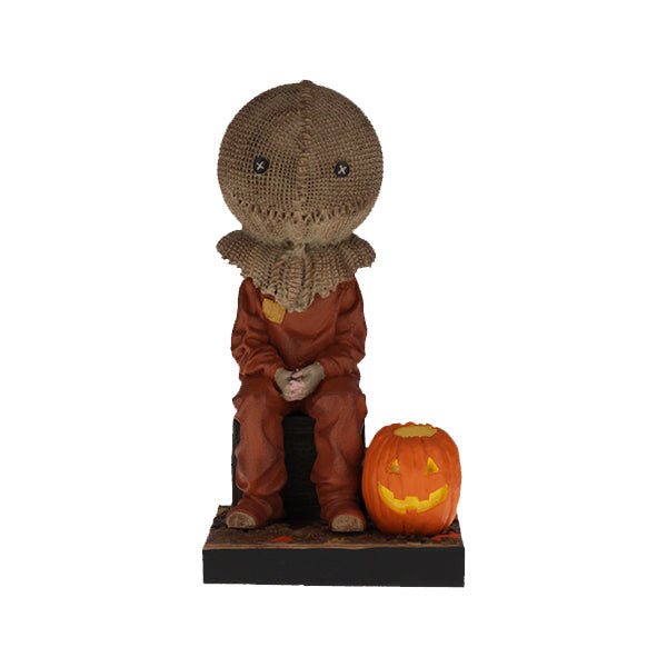 Trick 'r Treat Sam Sitting Bobblehead, a 6-inch collectible figure presenting Sam with pumpkin-like head, perfect for Halloween decor and horror enthusiasts.