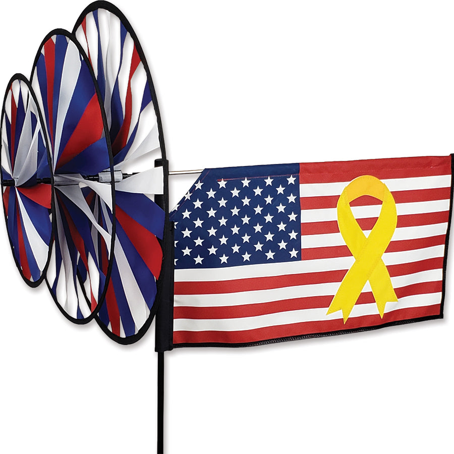 Triple Spinner - Yellow Ribbon displaying a vibrant design in an outdoor garden setting, showcasing POW/MIA support in motion.