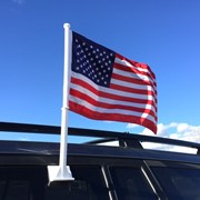 Vibrant U.S. Car Flag attached to a vehicle window, featuring the American flag design created from weather-resistant polyester fabric.