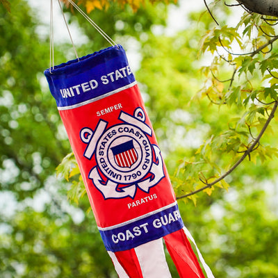 U.S. Coast Guard 40 inch windsock with detailed appliqued graphics and embroidered accents, fluttering outdoors in a garden setting.