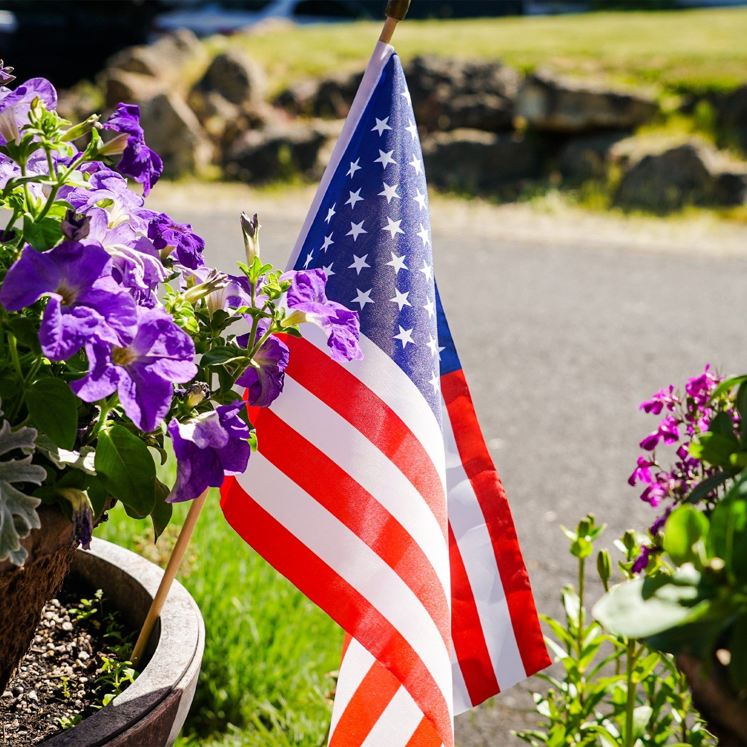 12x18 inch U.S. Stick Flags on wooden sticks, designed for outdoor use, displayed in a festive outdoor setting.