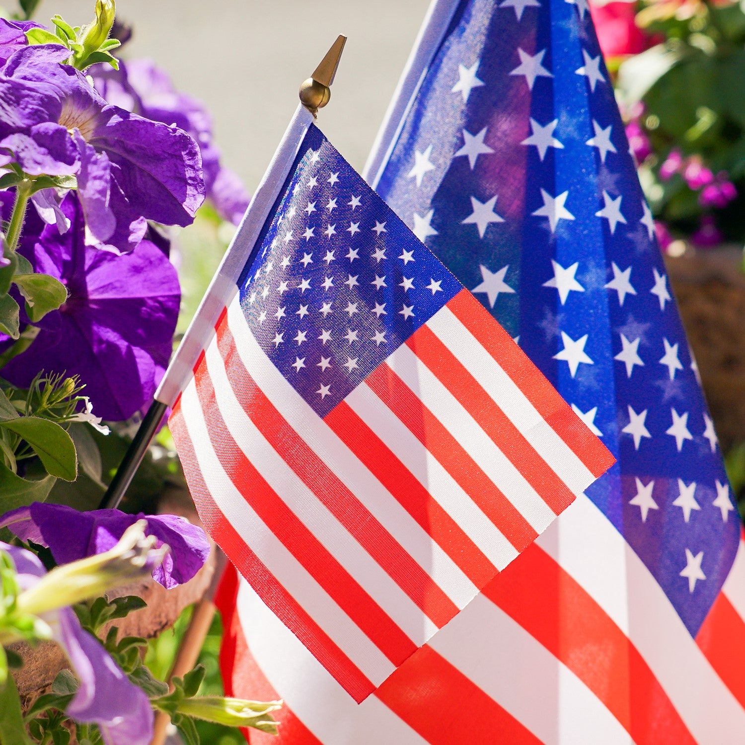 U.S. Flag 4x6 Stick Flag with vibrant stars and stripes on a black stick, ideal for holiday celebrations and outdoor decor displayed at a gathering.