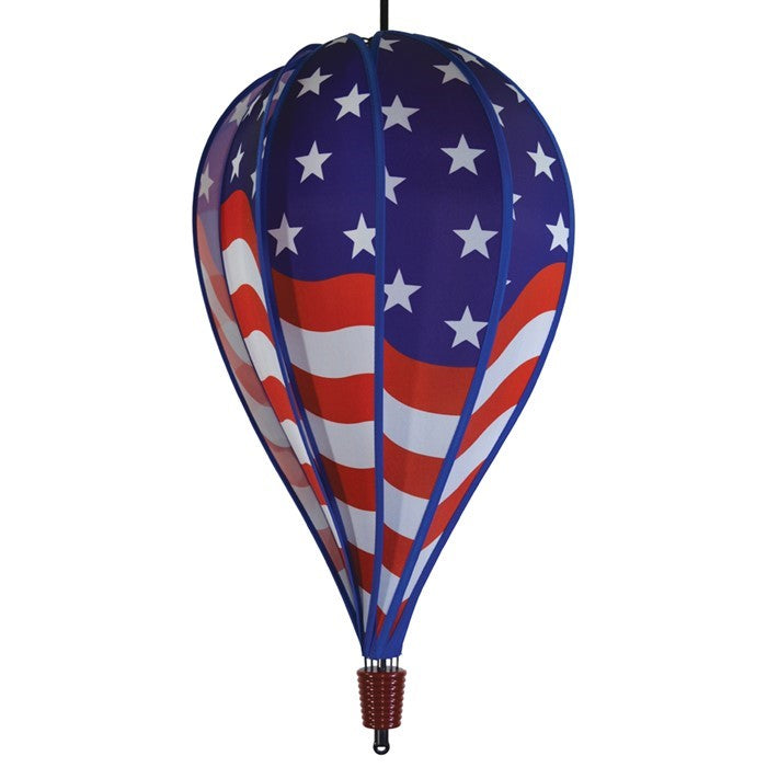 USA Flag 10-Panel Hot Air Balloon spinning in a gentle breeze, showcasing a vibrant American flag design in an outdoor garden setting.