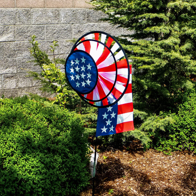 USA Flag Dual Spinner Wheels with red, white and blue design in a garden setting, featuring a garden flag and a robust pole for display.