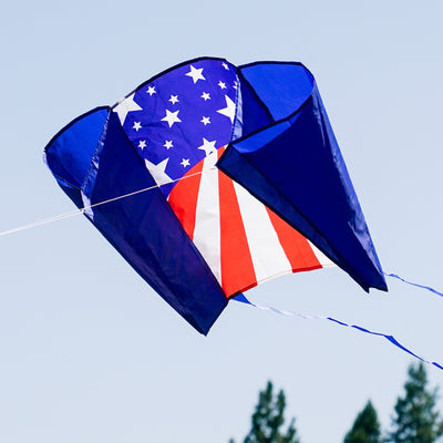 30-inch USA Sled Kite with vibrant Stars and Stripes design soaring against a blue sky, showcasing its easy-flying characteristics and stability.
