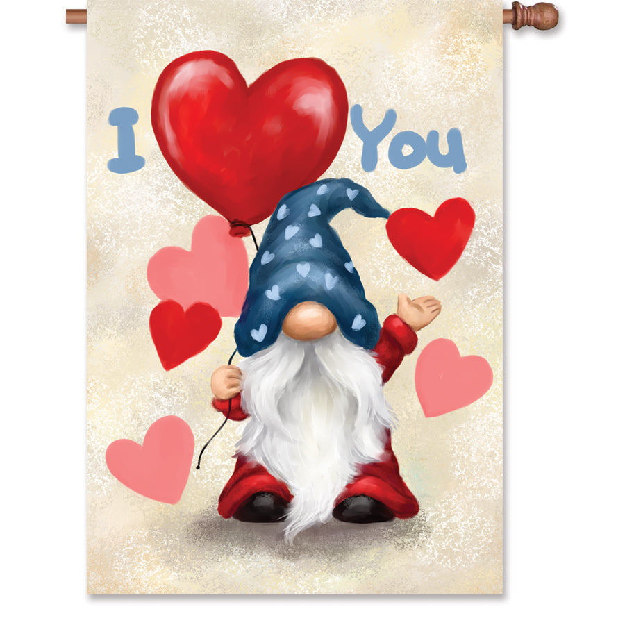 28 in. Valentine Gnome house flag depicting a cheerful gnome with hearts, beautifully displayed outdoors near a garden.