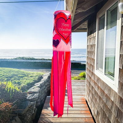 Valentine's Day 40-inch windsock with colorful heart appliques, fluttering gently in the wind, displayed outdoors on a sunny day.