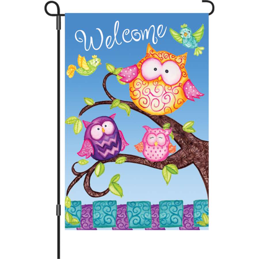 12 In. Welcome Owls garden flag featuring colorful owls and foliage, displayed outdoors for a cheerful welcome effect.