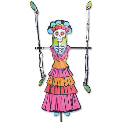 WhirliGig Spinner - Day of the Dead Woman spinning in a garden, showcasing vibrant colors and intricate patterns against the backdrop of outdoor greenery.