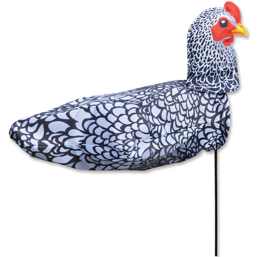 Windicator - Chicken weather vane swaying in the wind on a sturdy pole, adding whimsy and fun to an outdoor garden setting.
