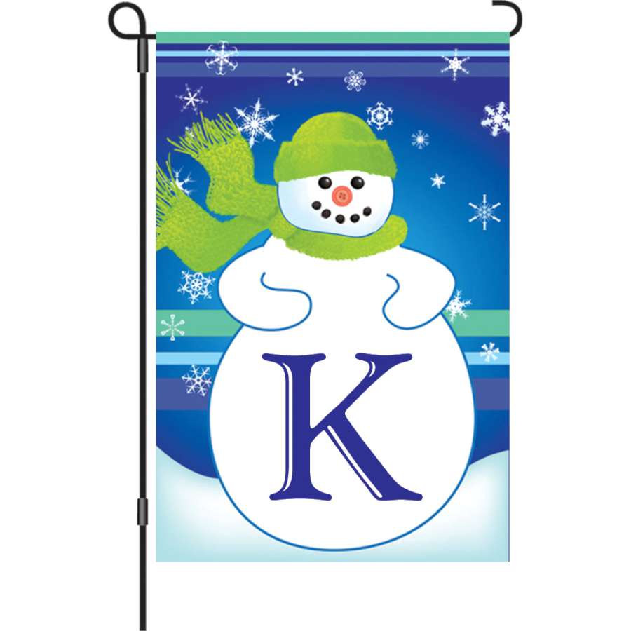 12 in. Winter Monogram Flag - K features a vibrant monogram design displayed outdoors in a garden setting for winter.