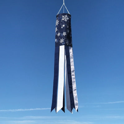 Winter Wonderland 40-inch windsock featuring a snowflake design in blue and white, gently fluttering outdoors in the winter breeze.