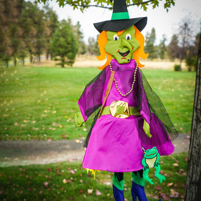 Witch Wind Friend 3D windsock design featuring a witch and frog, hanging outdoors in a colorful garden setting, perfect for Halloween.
