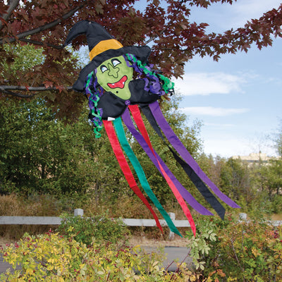 Witch Windtail Halloween decoration featuring a green witch with flowing hair and fluttering colorful tails hung outdoors, showcasing its festive design.