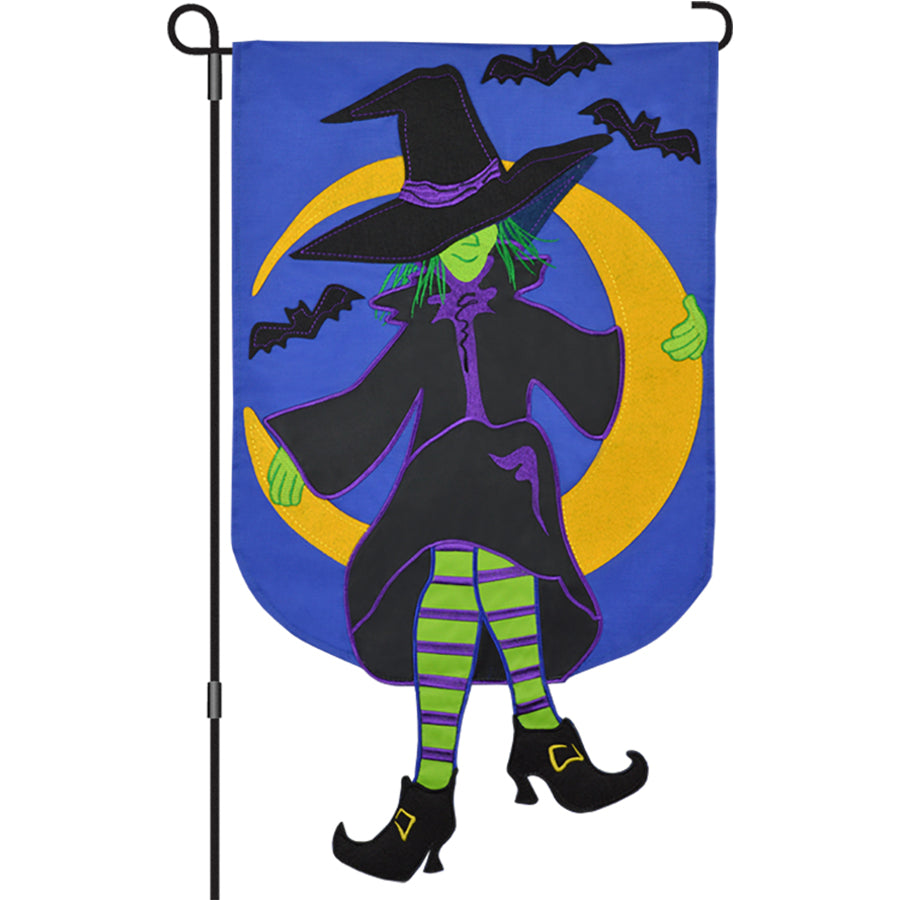 Witchy Moon garden flag featuring an embroidered witch sitting on a crescent moon surrounded by bats displayed on a garden flag pole.