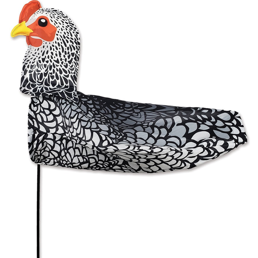 XL Windicator Weather Vane featuring a whimsical chicken design, inflated and dancing in the wind atop a sturdy pole in a garden setting.