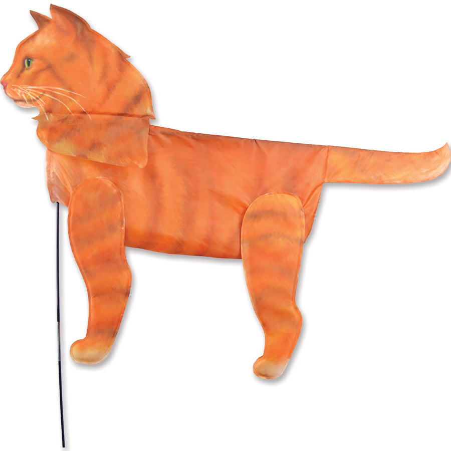 XL Windicator Weather Vane in the shape of an orange cat, dancing in the breeze atop a sturdy fiberglass pole set in a garden.