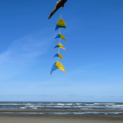 Yellow & Blue Resin Fish Mobile beautifully reflects sunlight, showcasing vibrant colors in a unique hanging design-great for porches and outdoor spaces.